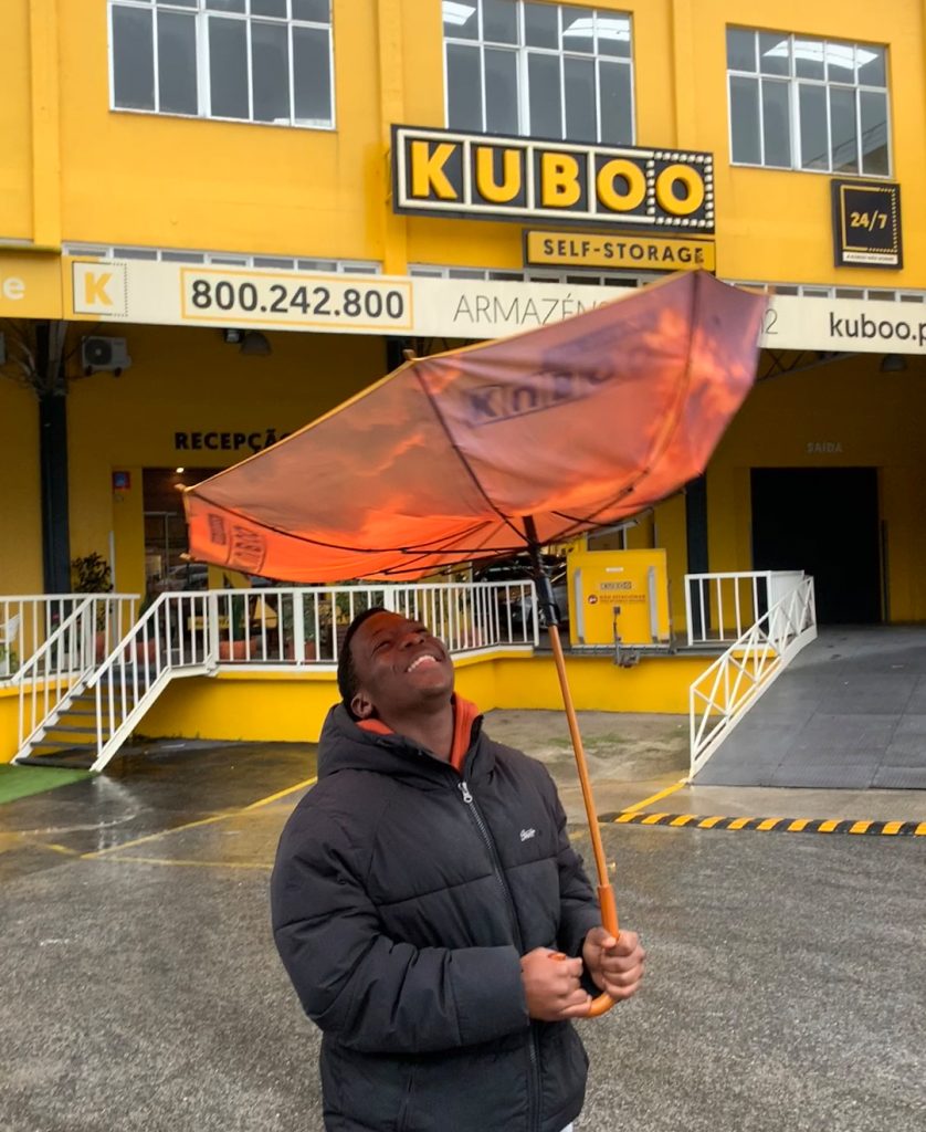 jovem sorridente segura guarda-chuva na kuboo carnaxide