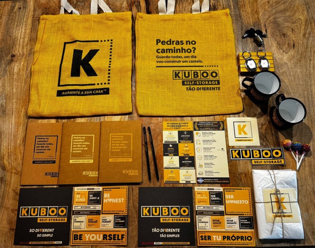 a variety of kuboo merchandise, tote bags, mugs, keychains, stickers, pencils, flyers, notebooks, etc