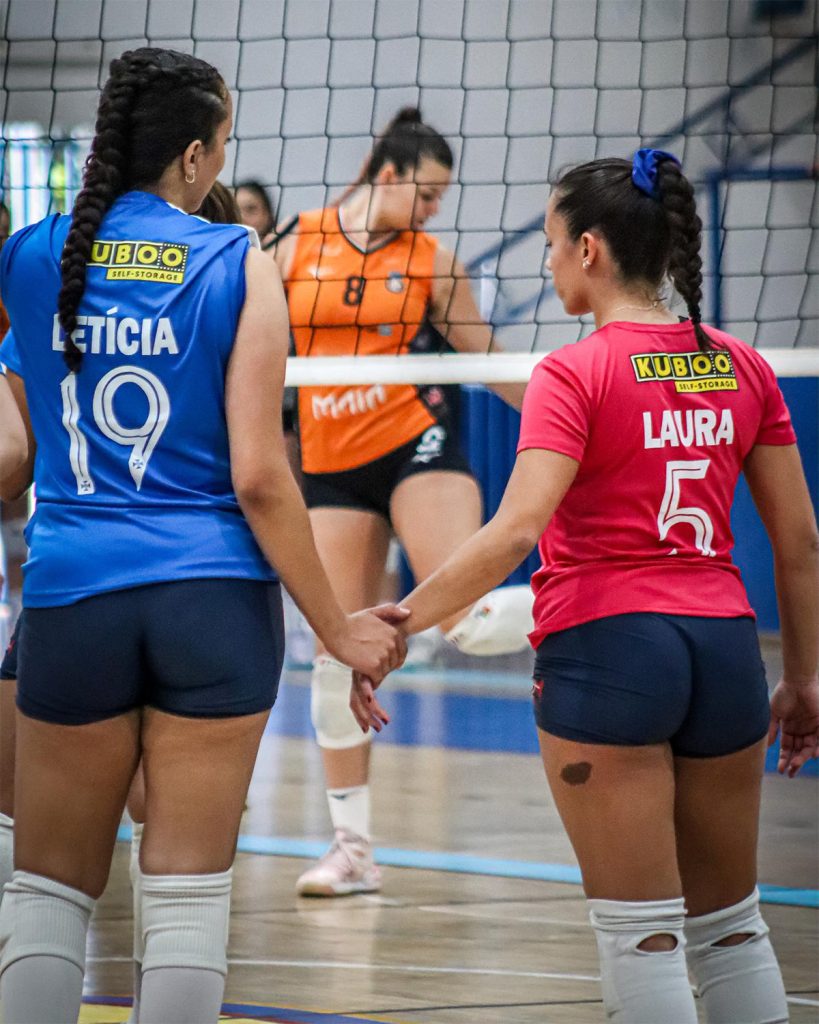 two volleyball players with kuboo sponsorship holding hands
