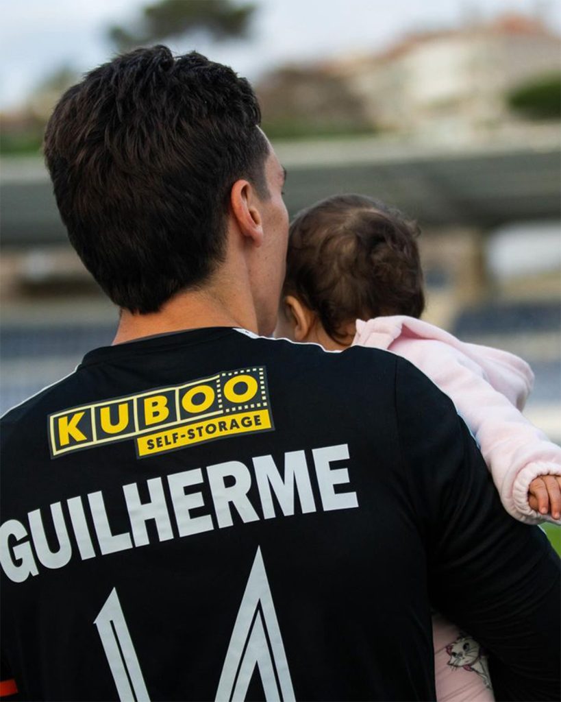 football player with kuboo self-storage sponsorship holding child